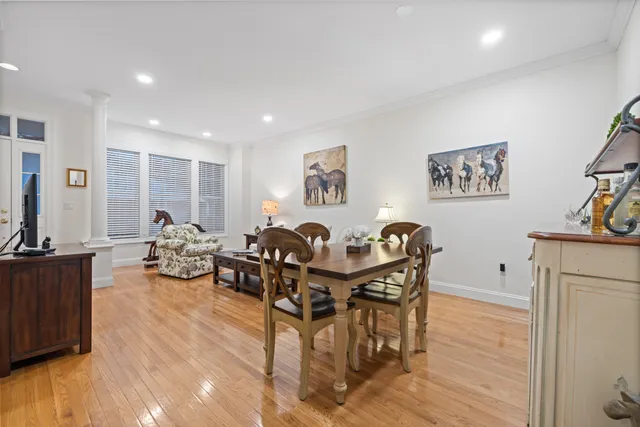 a view of a dining room with furniture a chandelier and wooden floor