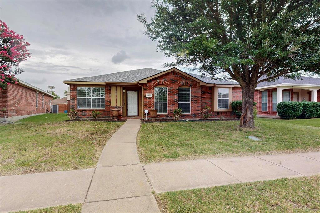 a front view of a house with a garden and trees