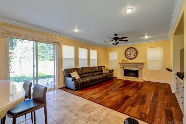 a living room with a couch a fireplace and a large window with garden view