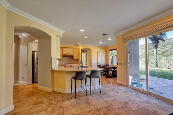 a view of a kitchen with kitchen island granite countertop a large counter top furniture and stainless steel appliances