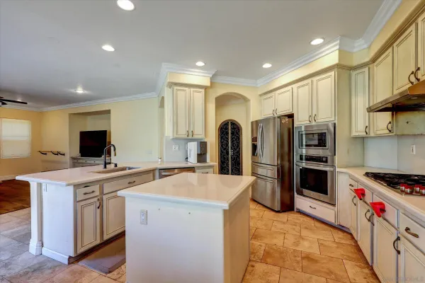a kitchen that has a lot of cabinets and stainless steel appliances
