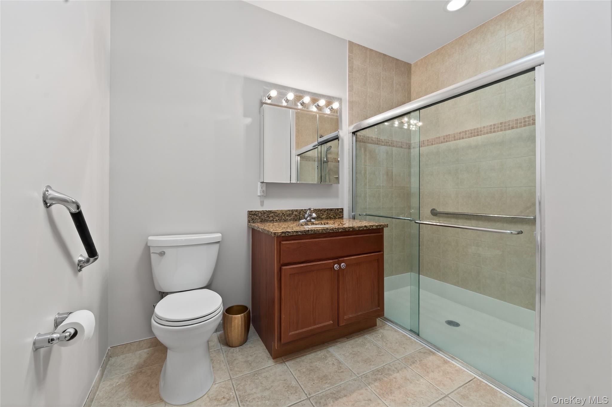 294 Spring Drive East Meadow, NY 11554 - Photo 15 of 31 Bathroom with vanity, a shower stall, and light tile patterned floors