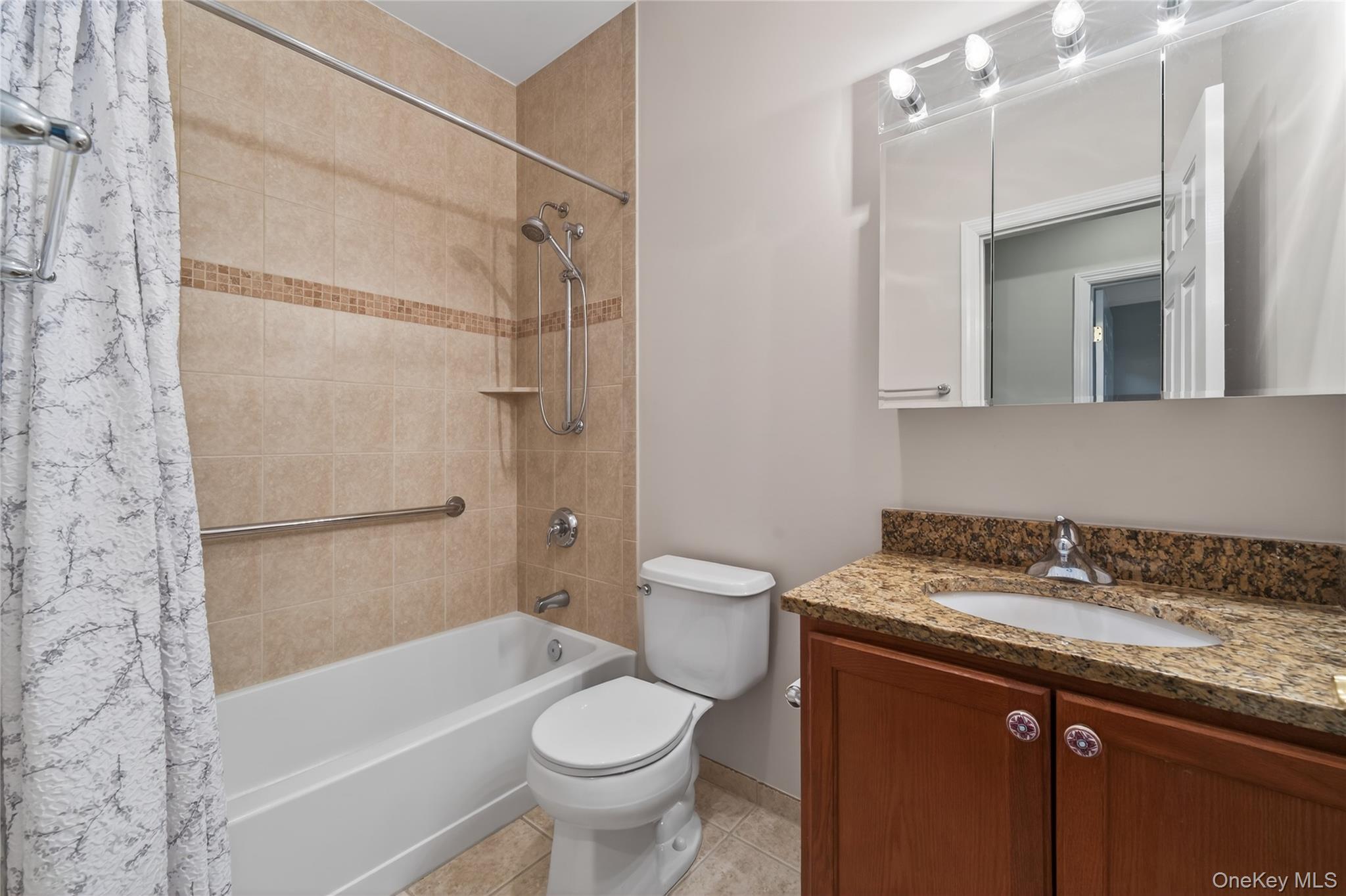 294 Spring Drive East Meadow, NY 11554 - Photo 17 of 31 Bathroom with shower / bath combo, vanity, and light tile patterned floors