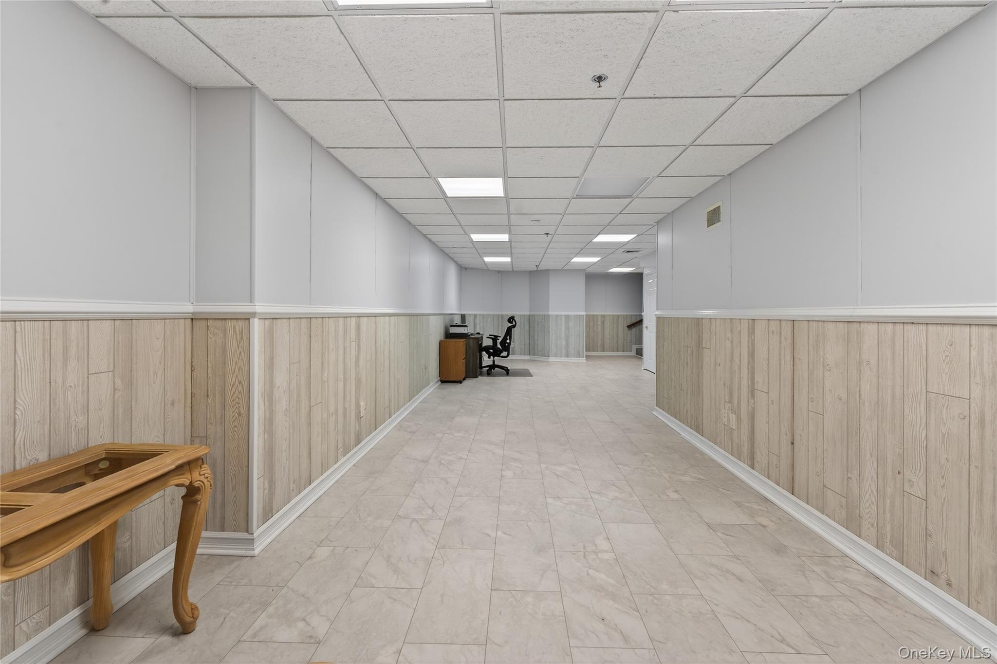 294 Spring Drive East Meadow, NY 11554 - Photo 19 of 31 Corridor featuring wood walls, a paneled ceiling, and wainscoting