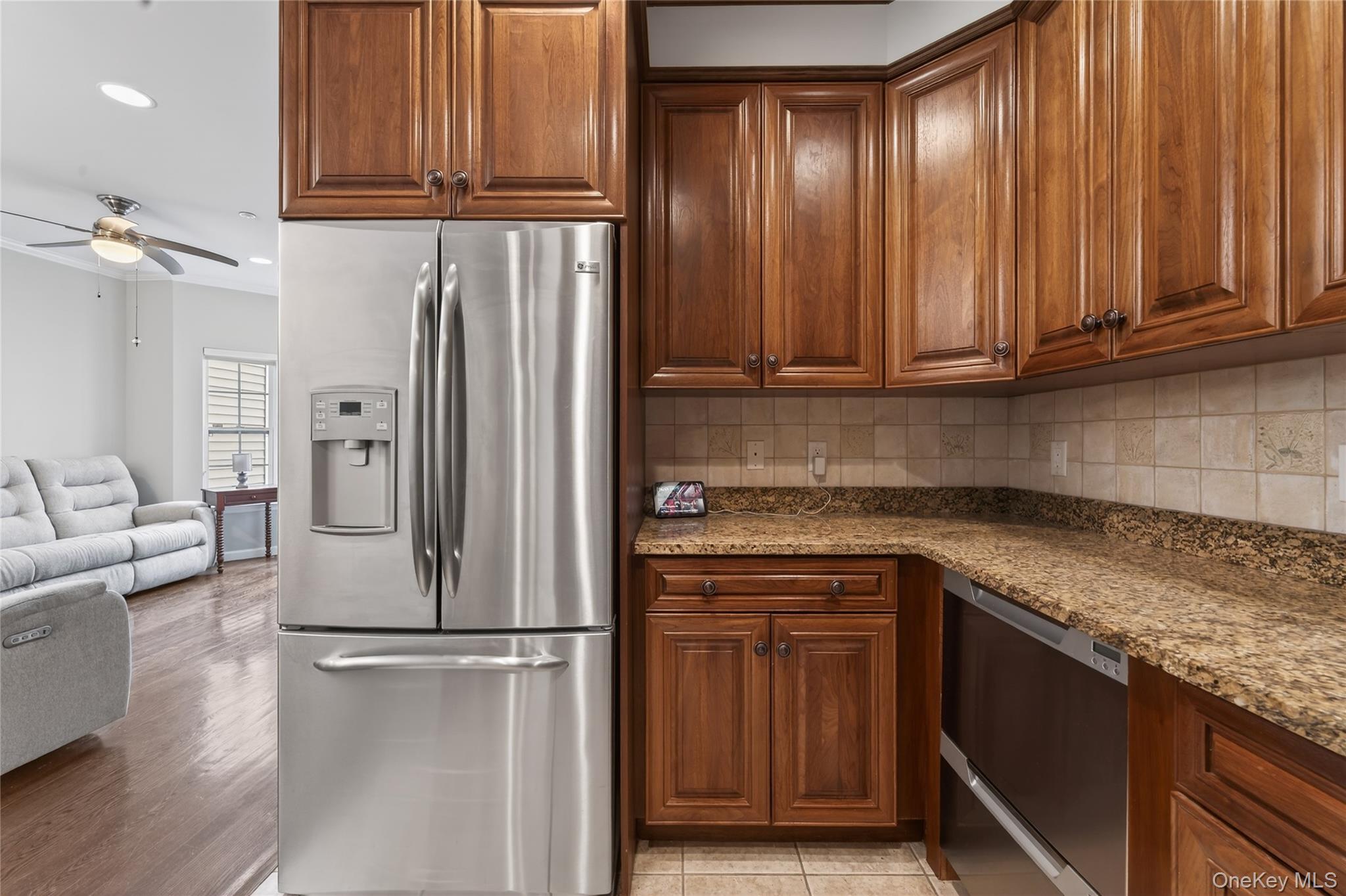 294 Spring Drive East Meadow, NY 11554 - Photo 10 of 31 Kitchen with stainless steel appliances, dark stone countertops, brown cabinetry, decorative backsplash, and recessed lighting