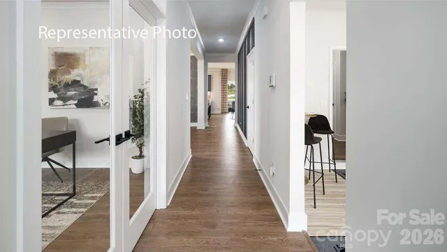 a view of a hallway with wooden floor and staircase