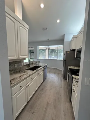 a kitchen with stainless steel appliances granite countertop a sink stove and refrigerator