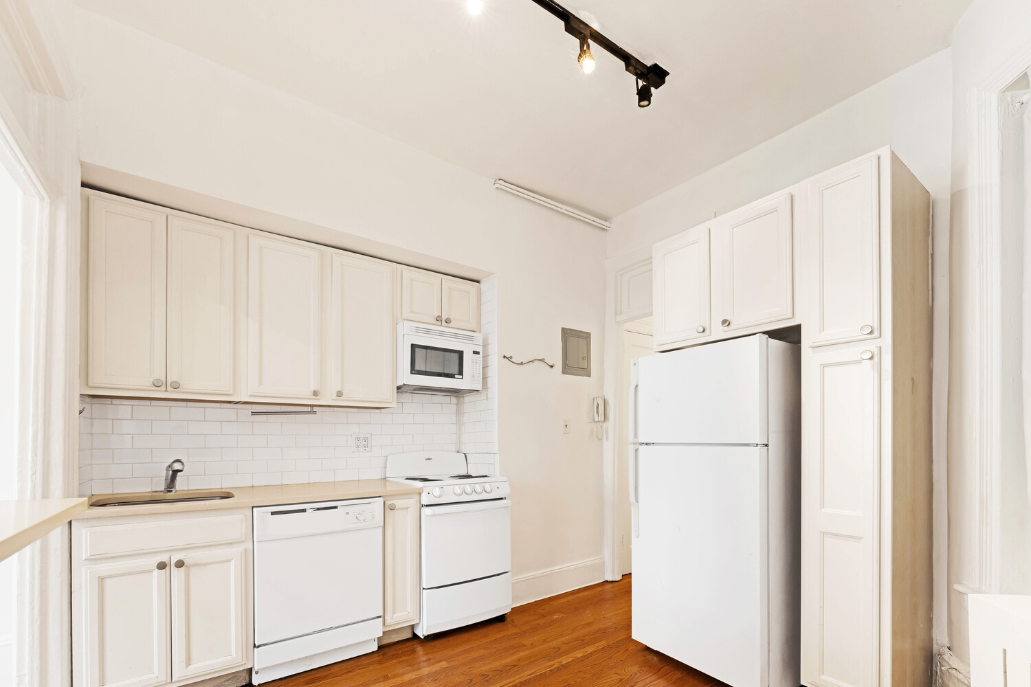192 Bleecker Street, Unit 14 Manhattan, NY 10012 - Photo 5 of 17 a kitchen with white cabinets and white appliances