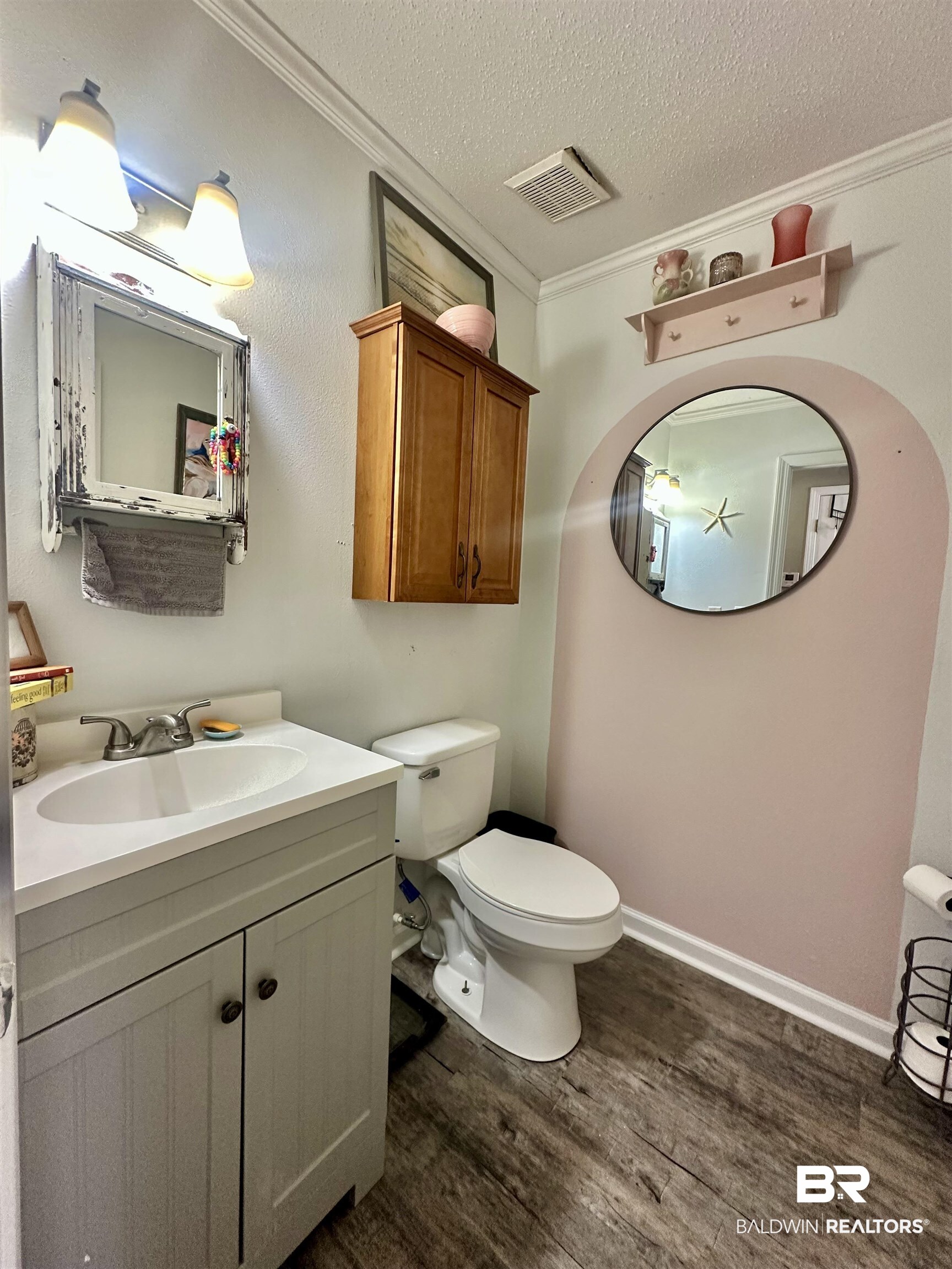 120 McGougin Road Brewton, AL 36426 - Photo 14 of 21 Half bathroom featuring crown molding, visible vents, toilet, a textured ceiling, and wood finished floors