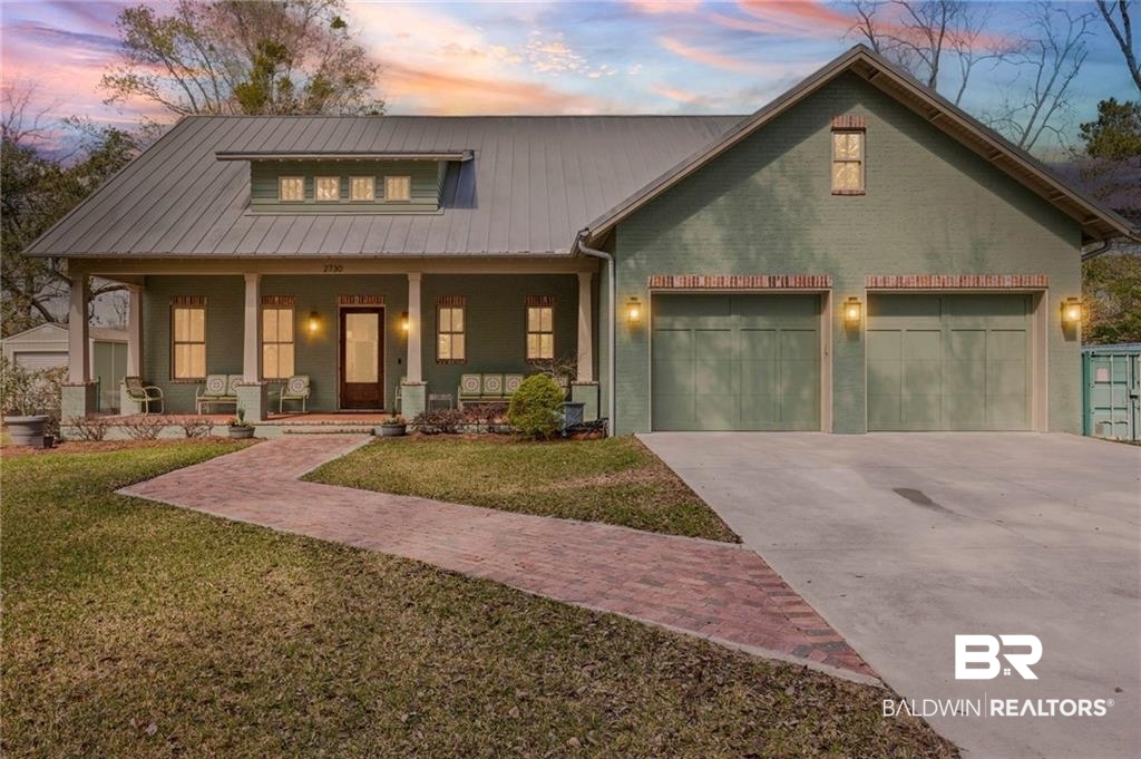 2730 Gator Road Mobile, AL 36605 - Photo 41 of 42 View of front of home with covered porch, driveway, an attached garage, a lawn, and brick siding