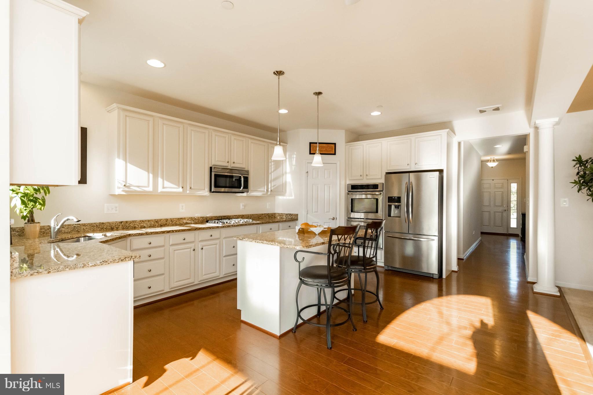 4117 Sweet Air Road Baldwin, MD 21013 - Photo 12 of 30 a kitchen with stainless steel appliances granite countertop a refrigerator a stove top oven a sink dishwasher and white cabinets with wooden floor