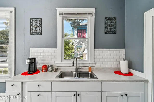 a kitchen with a sink wooden cabinets and a window