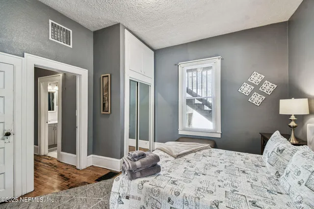 a bedroom with a bed and a couch next to a window