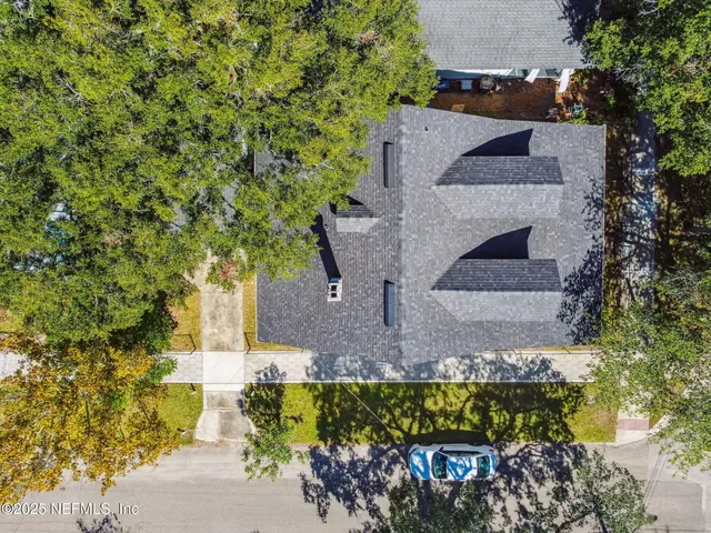 an aerial view of residential houses with outdoor space and parking