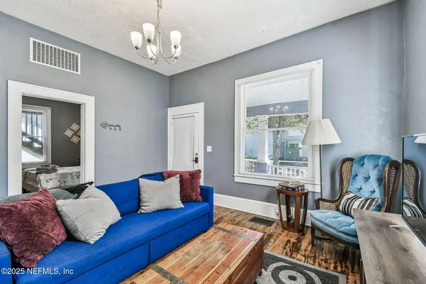 a living room with furniture a chandelier and a flat screen tv