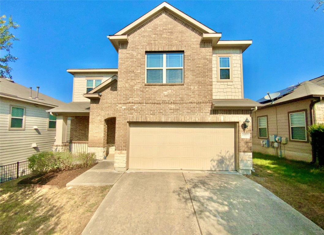 View of front of house featuring brick siding, an attached garage, driveway, and a porch