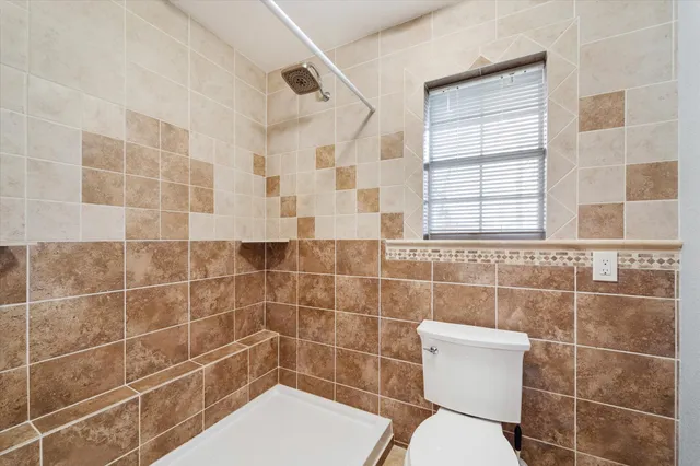 a bathroom with a toilet and a shower