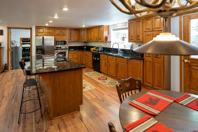a kitchen with stainless steel appliances granite countertop a stove a sink and a microwave