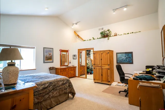 a bedroom with a bed and dresser with mirror