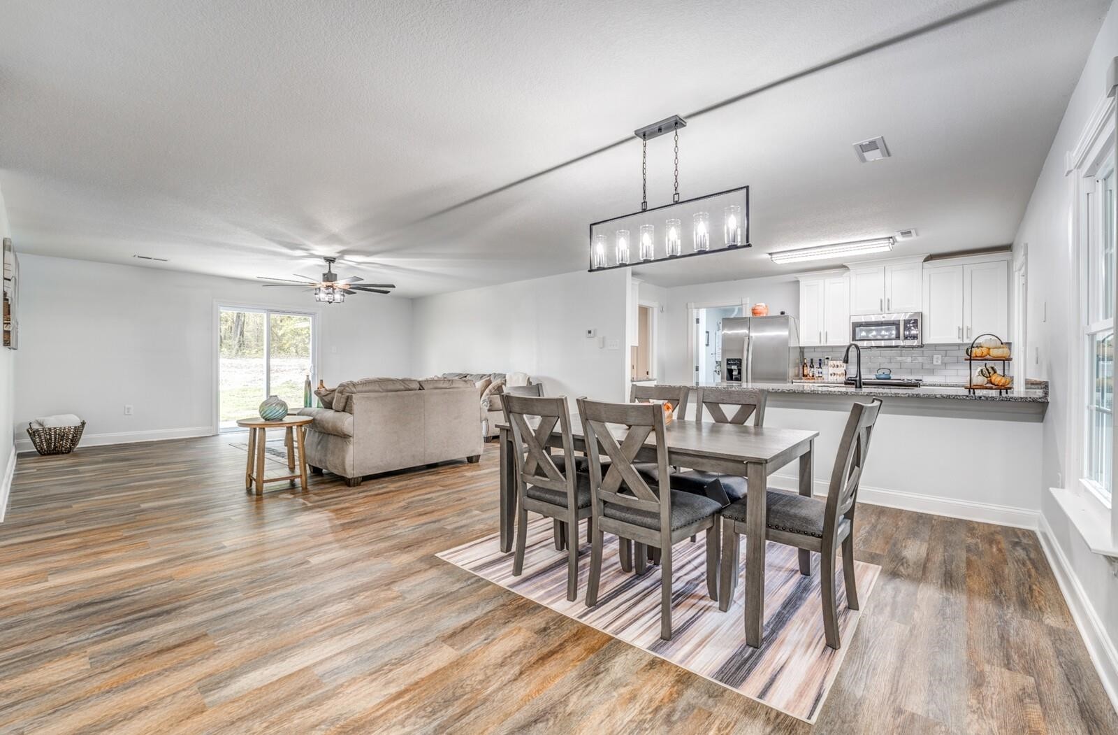 2100 Scrub Oak Road Mason, TN 38049 - Photo 5 of 28 a view of a dining room and livingroom with furniture wooden floor a rug a chandelier