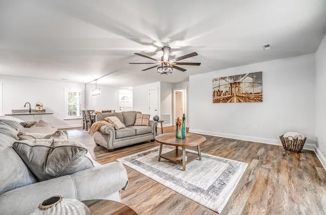 a living room with furniture and a wooden floor