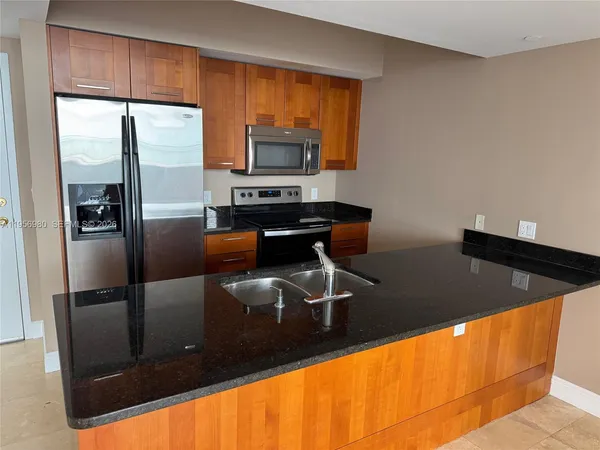 a kitchen with stainless steel appliances a refrigerator sink and microwave