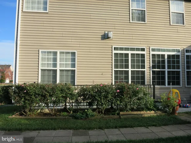 a front view of a house with a yard and potted plants