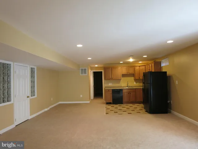 an open kitchen with a refrigerator and a sink