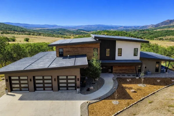 an aerial view of a house with swimming pool and mountain view