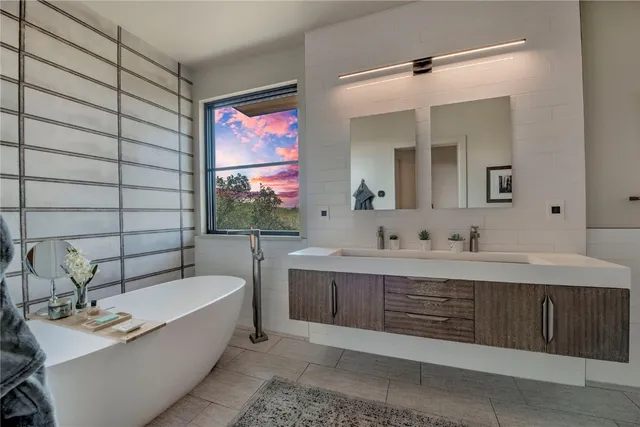 a bathroom with a bathtub sink vanity mirror and toilet