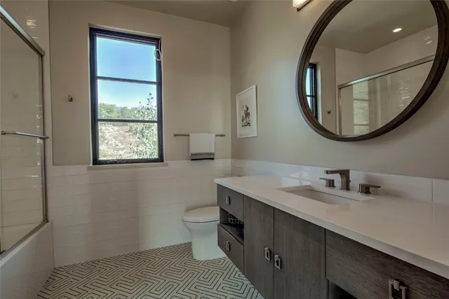 a bathroom with a toilet sink and mirror