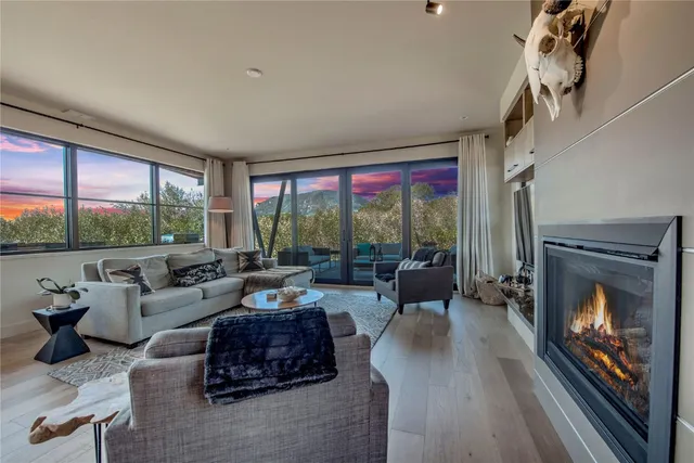 a living room with furniture large window and a fireplace