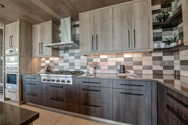 a kitchen with stainless steel appliances granite countertop a stove a sink and a refrigerator