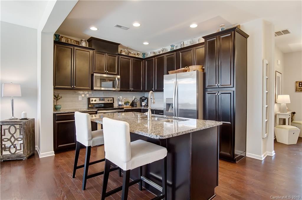 827 Ayrshire Avenue Fort Mill, SC 29708 - Photo 11 of 47 a kitchen with stainless steel appliances granite countertop a refrigerator a sink a stove a dining table and chairs