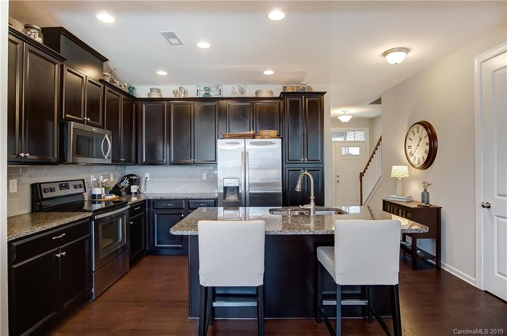 827 Ayrshire Avenue Fort Mill, SC 29708 - Photo 13 of 47 a kitchen with stainless steel appliances kitchen island granite countertop a sink a stove a dining table and chairs
