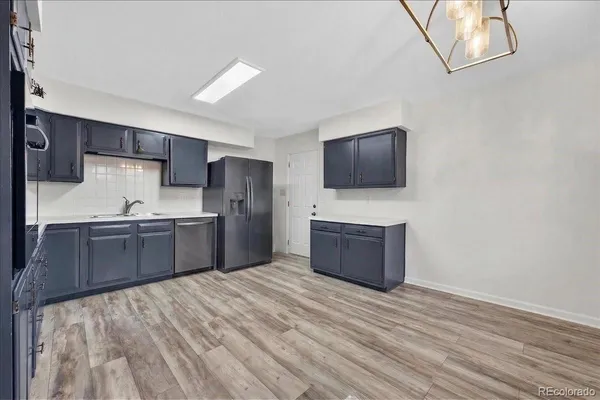 a kitchen with stainless steel appliances kitchen island granite countertop a stove a sink and a refrigerator