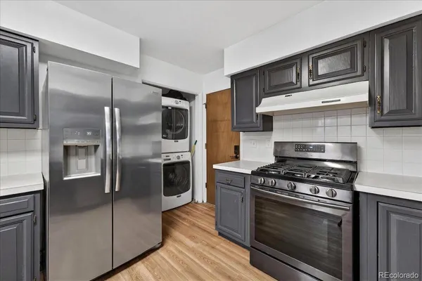 a kitchen with stainless steel appliances granite countertop a stove and a refrigerator