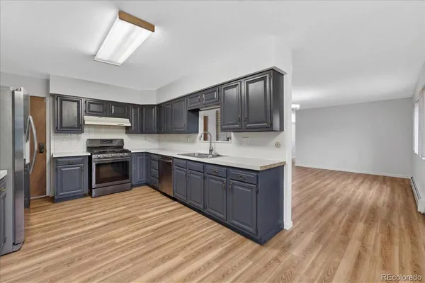 a kitchen with stainless steel appliances granite countertop a refrigerator and a stove top oven