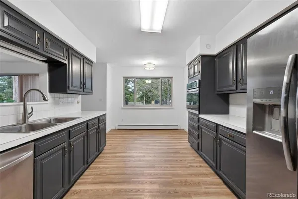 a kitchen with stainless steel appliances granite countertop a sink and wooden cabinets