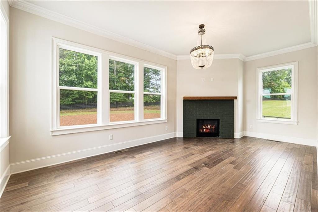 947 Hunter Way Milton, GA 30004 - Photo 35 of 78 an empty room with wooden floor fireplace and windows