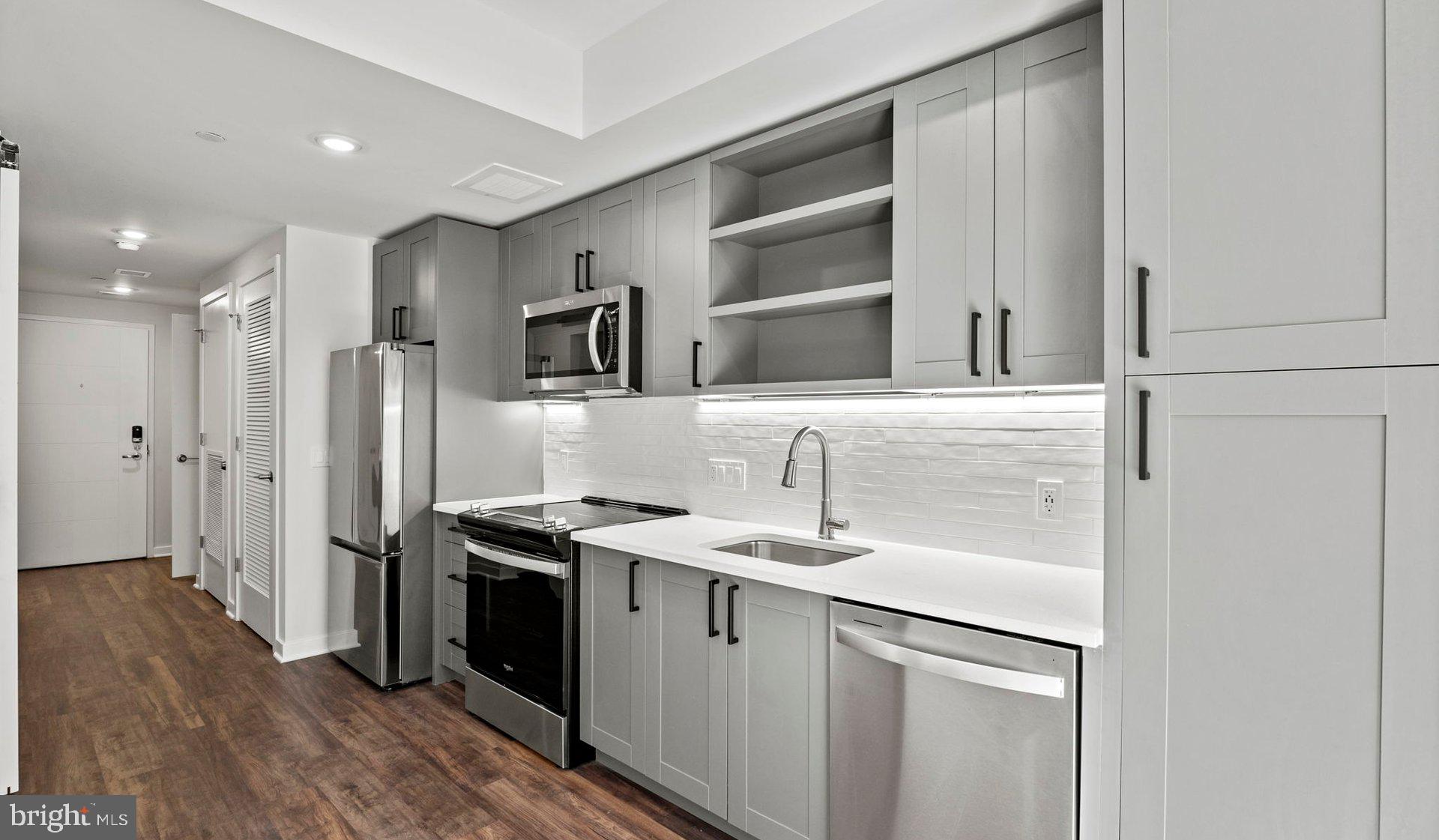 3990 Upton Street Northwest, Unit 2BPARCT110 Washington, DC 20016 - Photo 42 of 49 a kitchen with stainless steel appliances granite countertop a sink stove and refrigerator