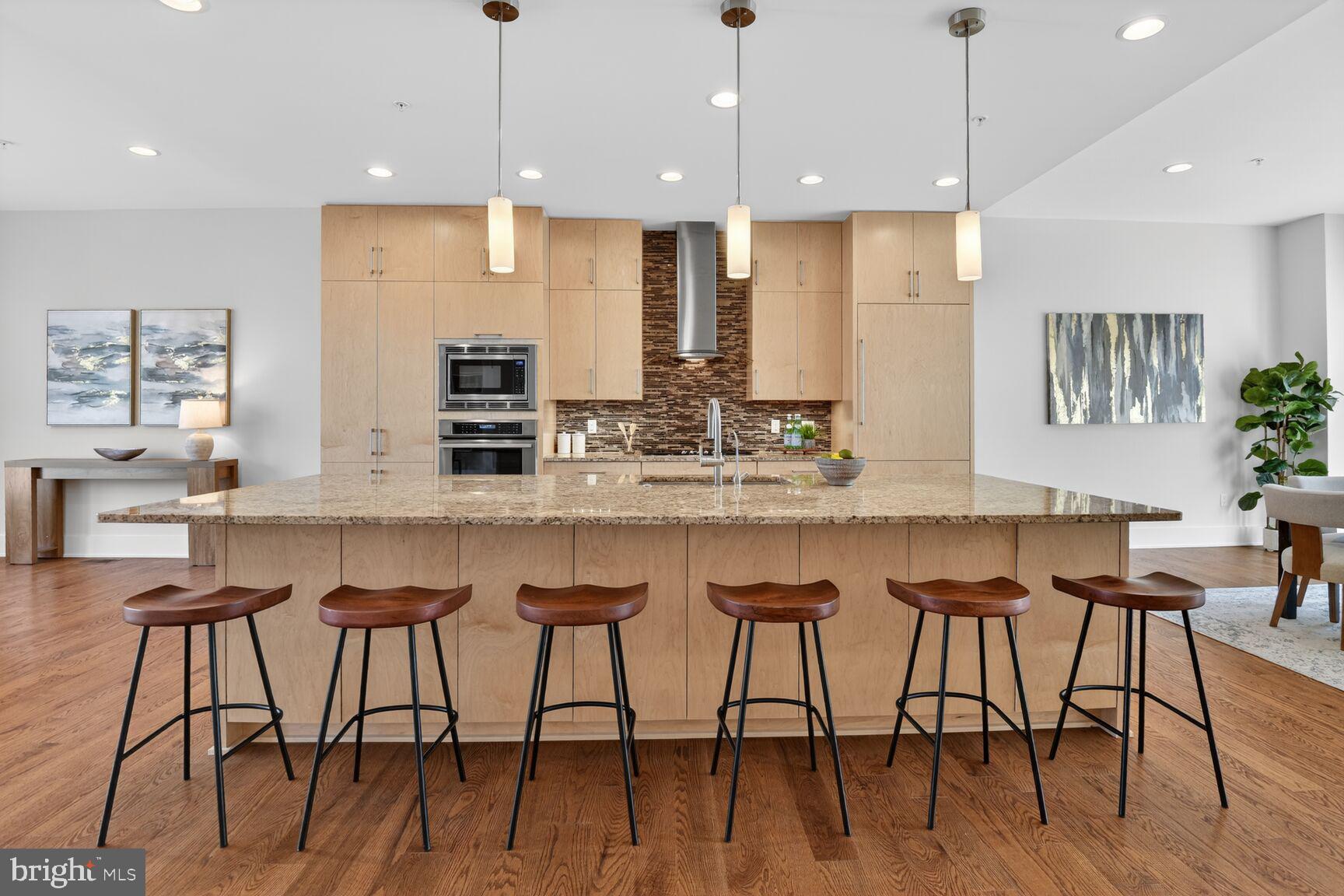 5320 Merriam Street Bethesda, MD 20814 - Photo 11 of 51 a kitchen with stainless steel appliances granite countertop a kitchen island and chairs in it