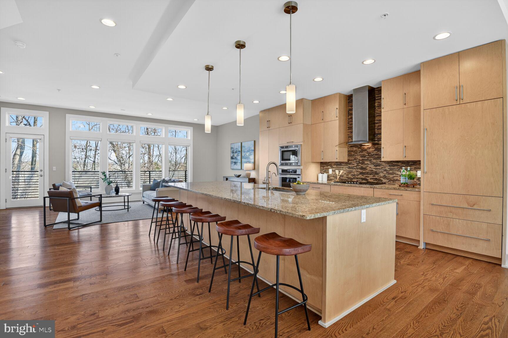 5320 Merriam Street Bethesda, MD 20814 - Photo 12 of 51 a kitchen with stainless steel appliances granite countertop a stove a sink a kitchen island with chairs and wooden floor