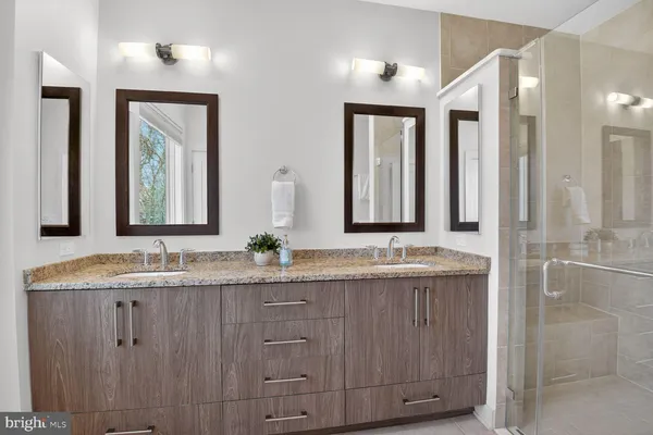 a bathroom with double vanity and a mirror