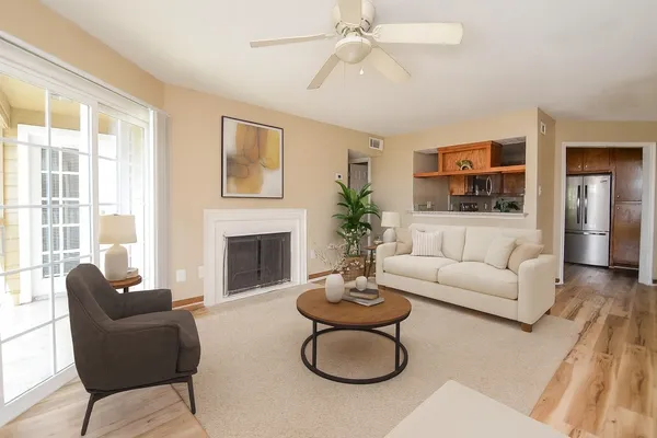 a living room with furniture a fireplace and a large window