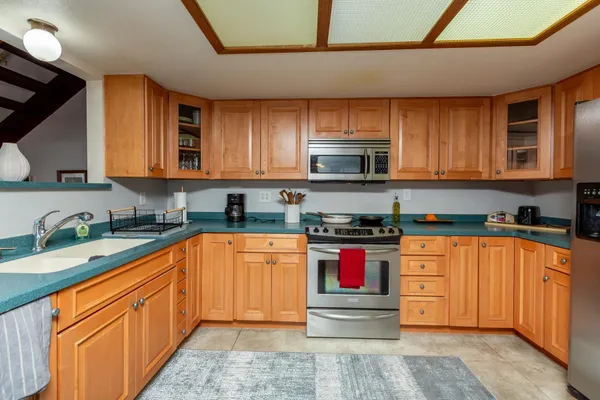 a kitchen with stainless steel appliances granite countertop a stove sink microwave and cabinets