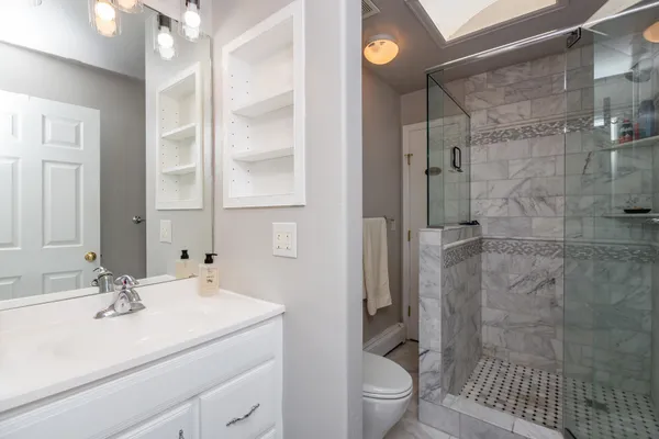 a bathroom with a sink toilet a mirror and shower