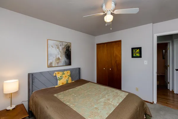 a bedroom with a bed and a lamp on dresser