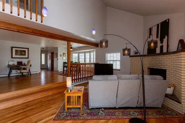 a living room with furniture a flat screen tv and a floor to ceiling window
