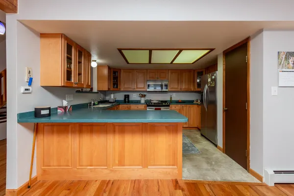 a kitchen with stainless steel appliances granite countertop a sink window and cabinets